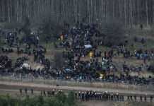 Поламаний паркан і тиснява: мігранти вийшли до білоруського КПП на кордоні з Польщею