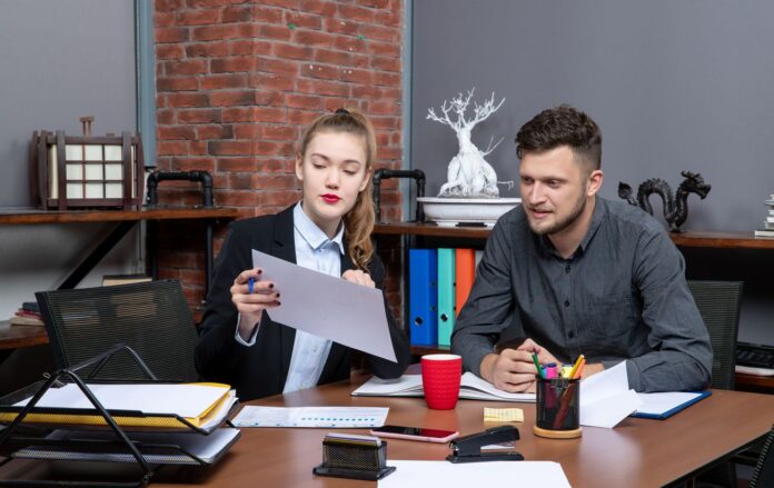 _ofis_divchina_i_cholovik_za_stolom_z_paperami_pratsevlashtuvannya_spivbesida_zarplatnya_freepik_com_5c4c0a51cc9a3c7401f1534c2f3c756a_1300x820