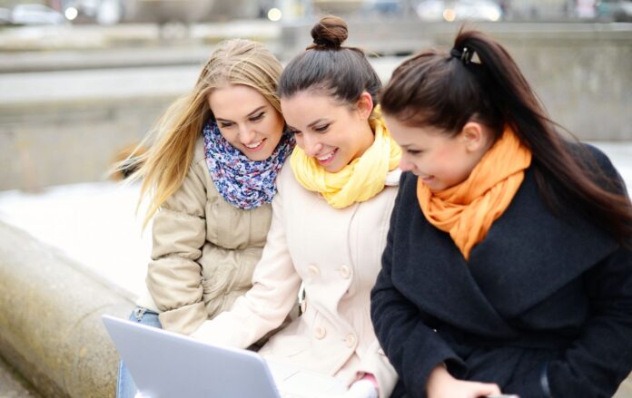 _z_noutom_tri_divchini_nadvori_holodno_usmishki_palto_sharfiki_gettyimages_525242729_cb60b227acde293fa82a24a11a89798d_1300x820