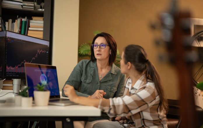 _dvi_zhinki_za_stolom_pered_monitorami_shi_ai_shtuchniy_intelekt_gettyimages_2231873023_b929fd462a359bd8d4354e01f7722381_1300x820