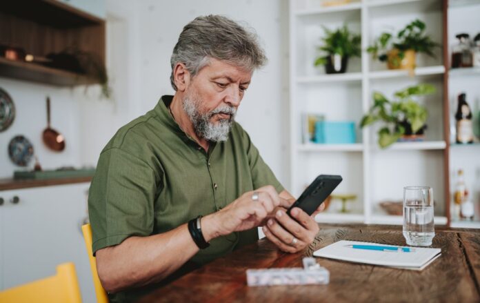 _pensioner_cholovik_dorosliy_siviy_z_borodoyu_za_stolom_pered_bloknotom_z_ruchkoyu_i_vodoyu_na_kuhni_zv_yazok_gettyimages_1719535353_f88874988e20bf3b0b81c6d9ba14af8b_1300x820